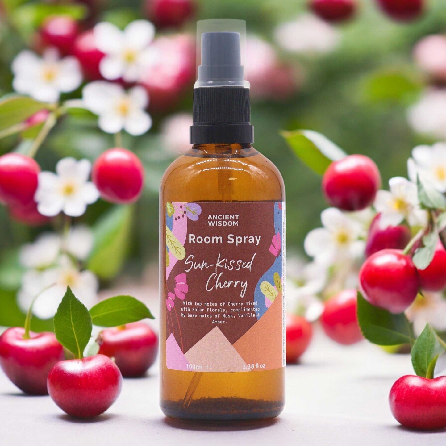 Ancient Wisdom Sun-Kissed Cherry room spray in a brown bottle with cherries and flowers.