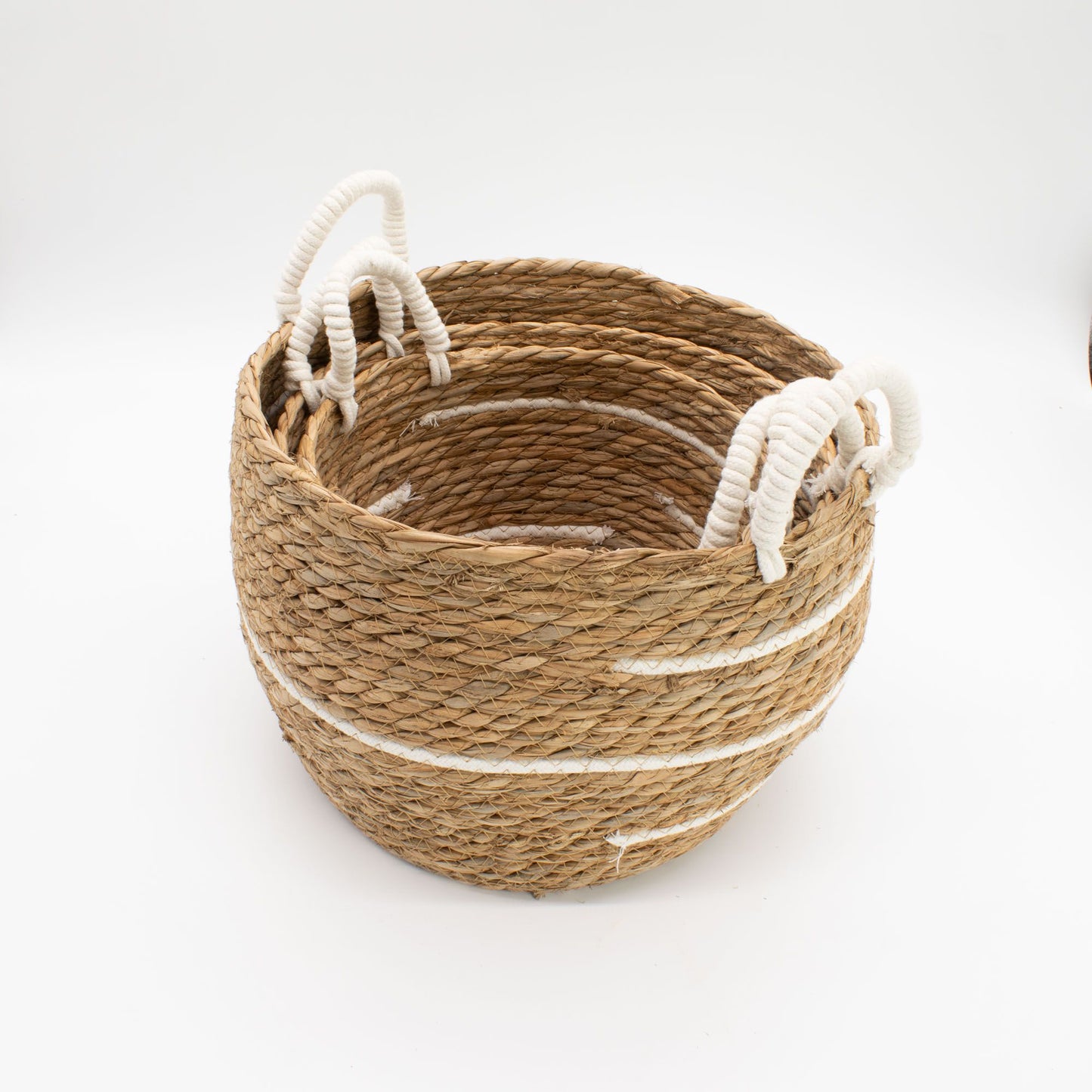 Set of 3 natural seagrass baskets with white stripes and rope handles.