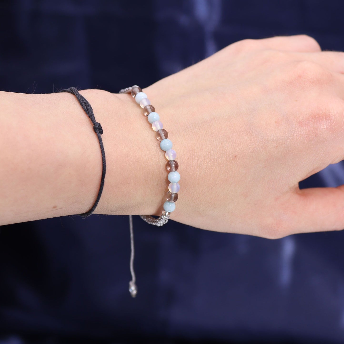 Arm mit einem Armband aus Aquamarin, Rauchquarz und Mondstein