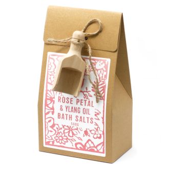 Braune Packung mit Badesalz, Rosenblüten und Holzschaufel.