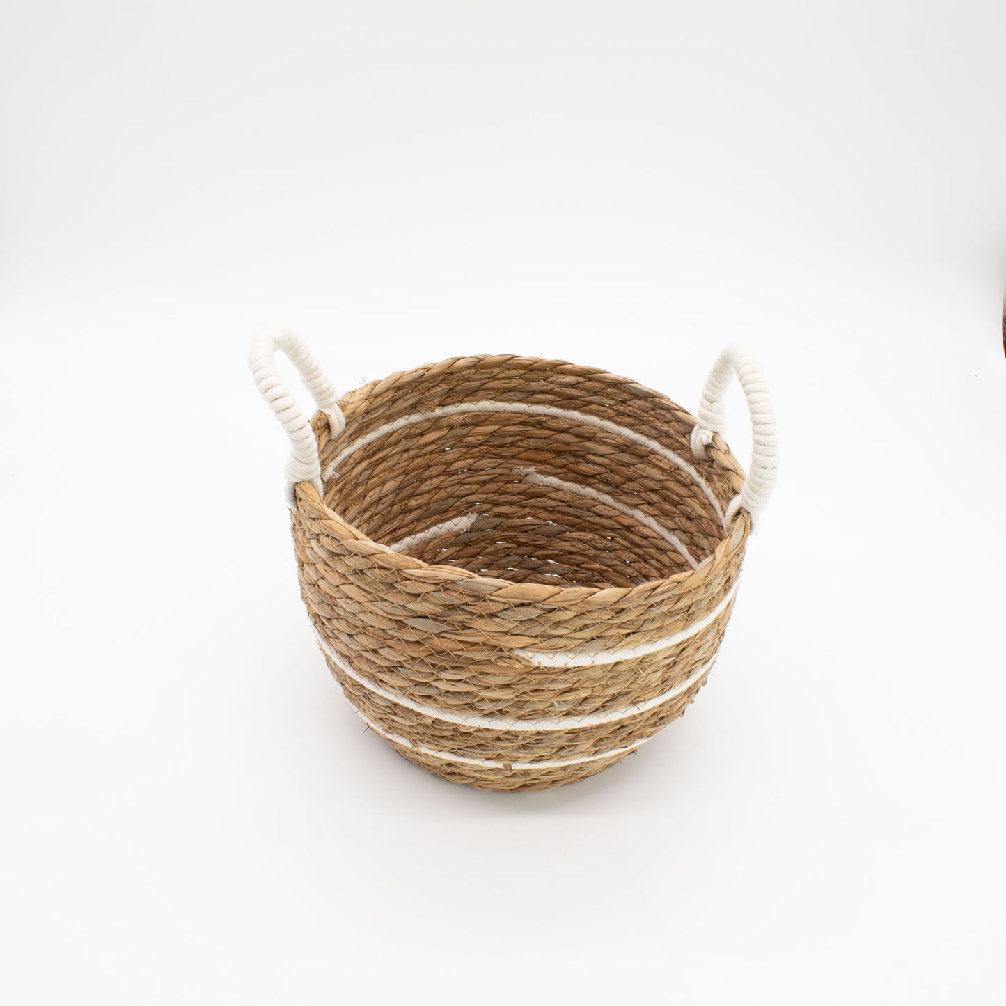 Round seagrass basket with white stripes and rope handles.