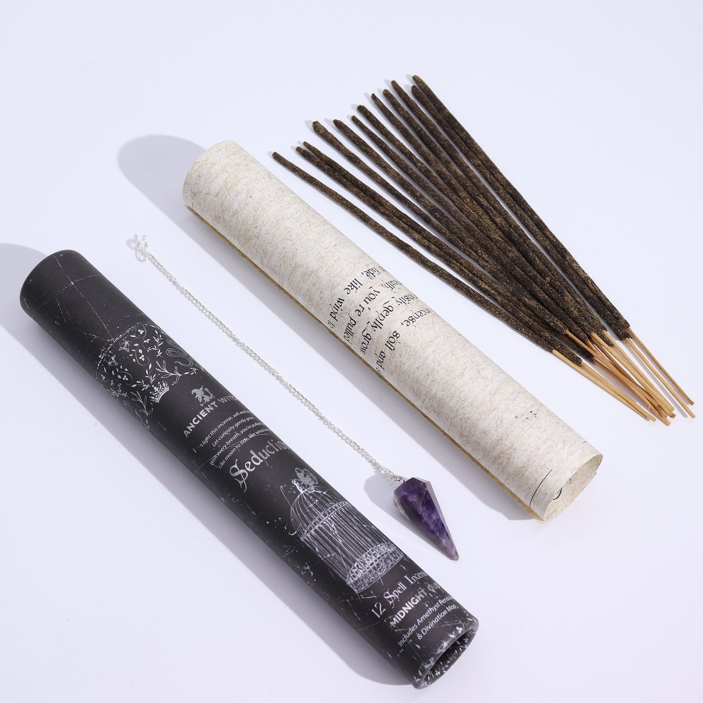 Räucherstäbchen und ein Amethyst-Pendel in einer schwarzen Röhre.
