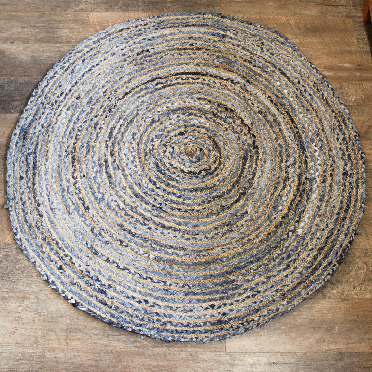 Runder Jute- und recycelter Denim-Teppich mit spiralförmigem Muster.