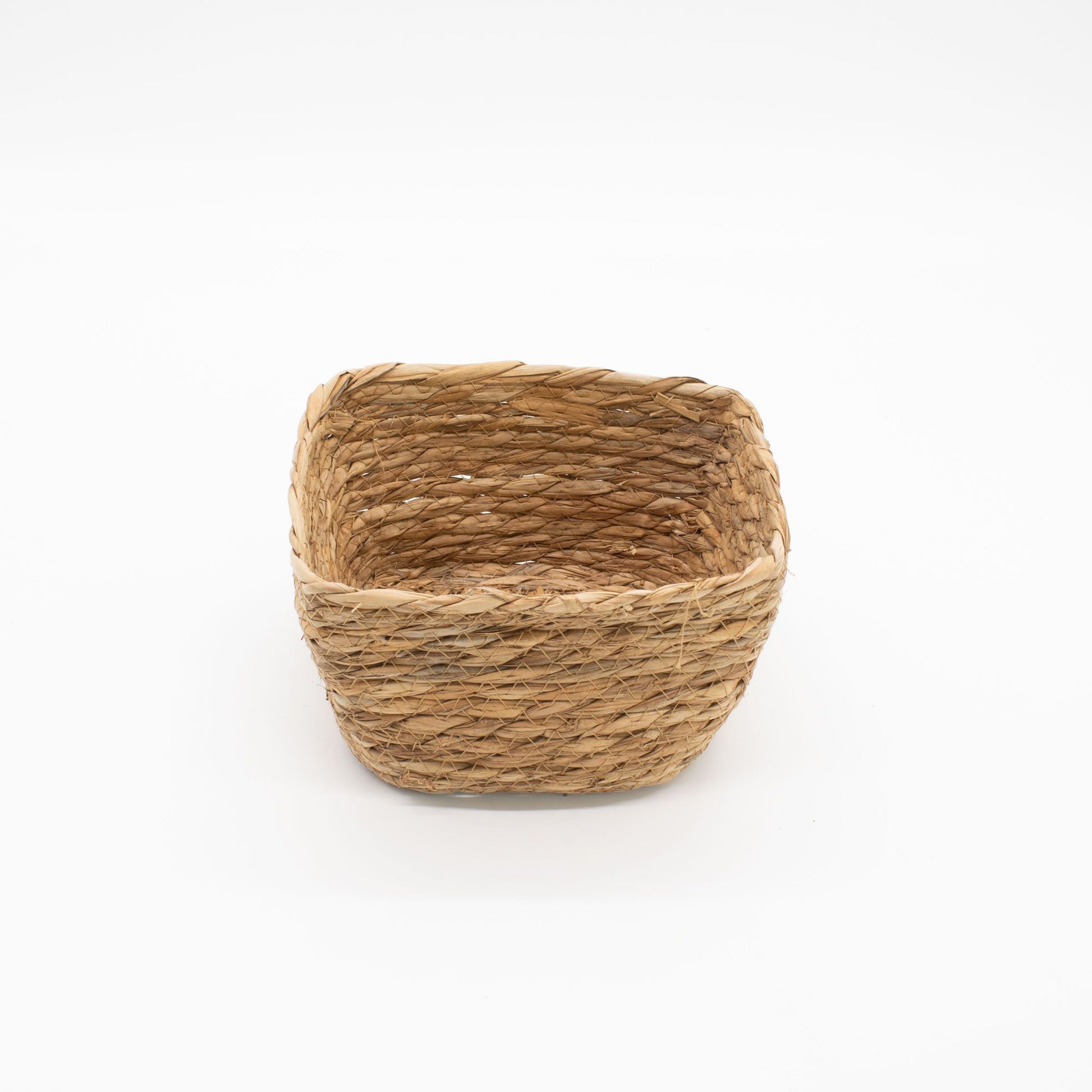 A natural seagrass square basket on a white background.