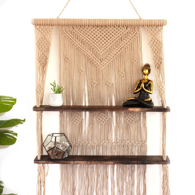 Dekoratives Makrame-Hängeregal mit zwei Holzablagen und Boho-Dekoration.