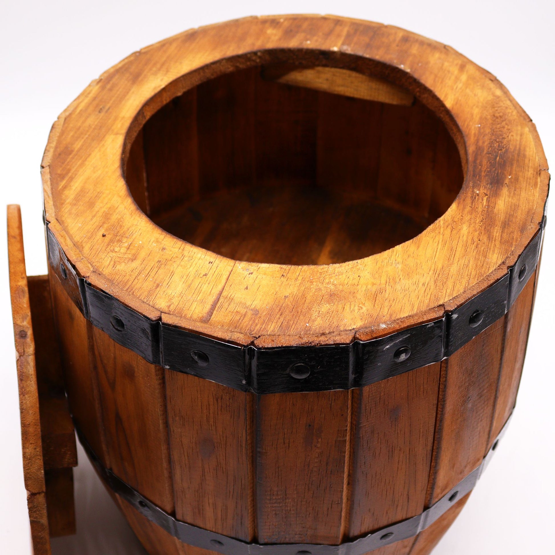 Ein runder Holzhocker im Bierfass-Design mit schwarzem Metallband und offenem Fach.