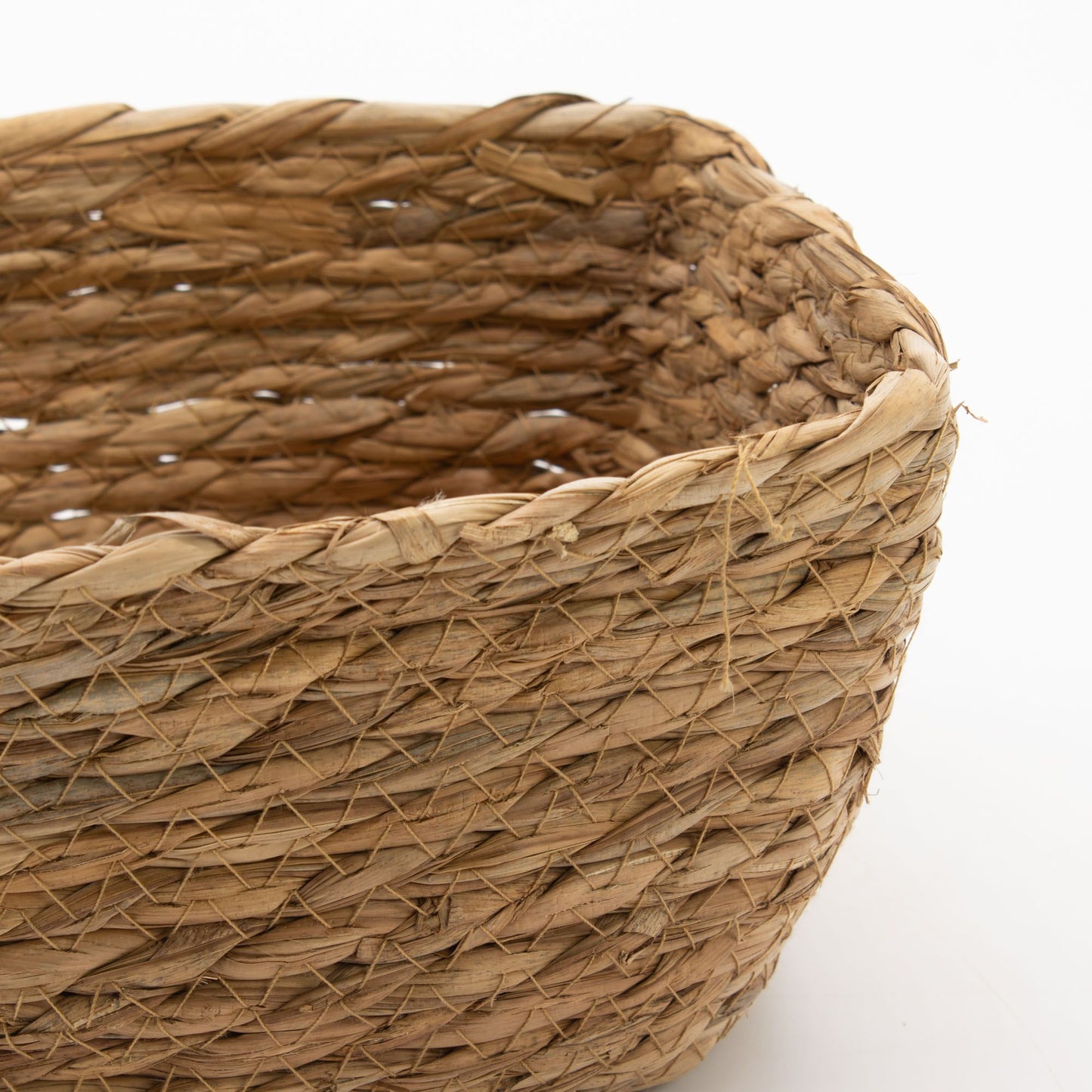 A close-up of a natural woven seagrass basket with a textured weave.