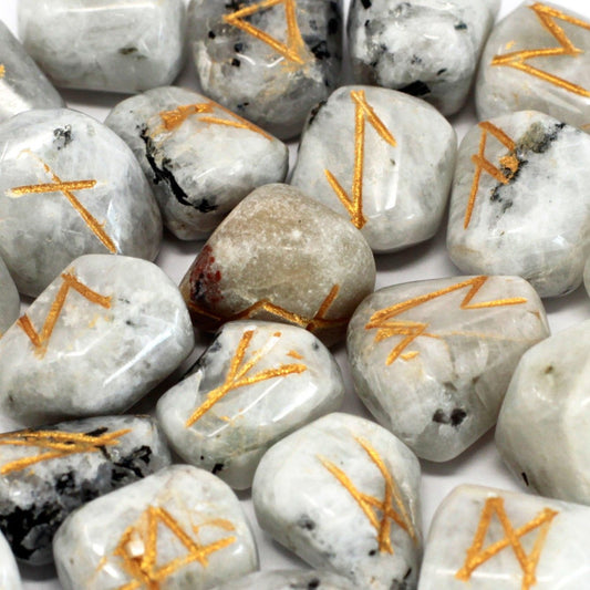 A set of rainbow moonstone rune stones with gold symbols.