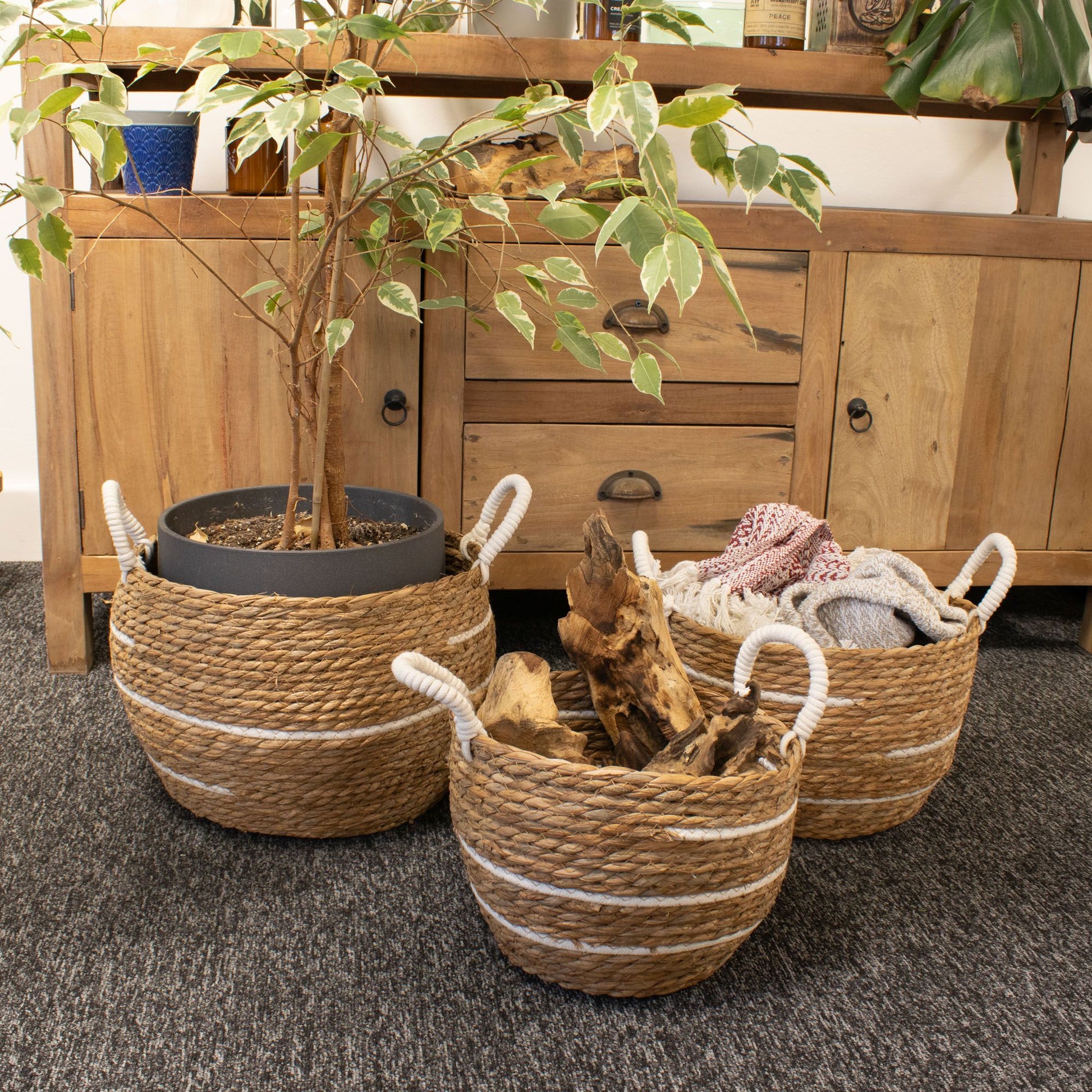 Set of 3 natural seagrass baskets with white stripes and rope handles.