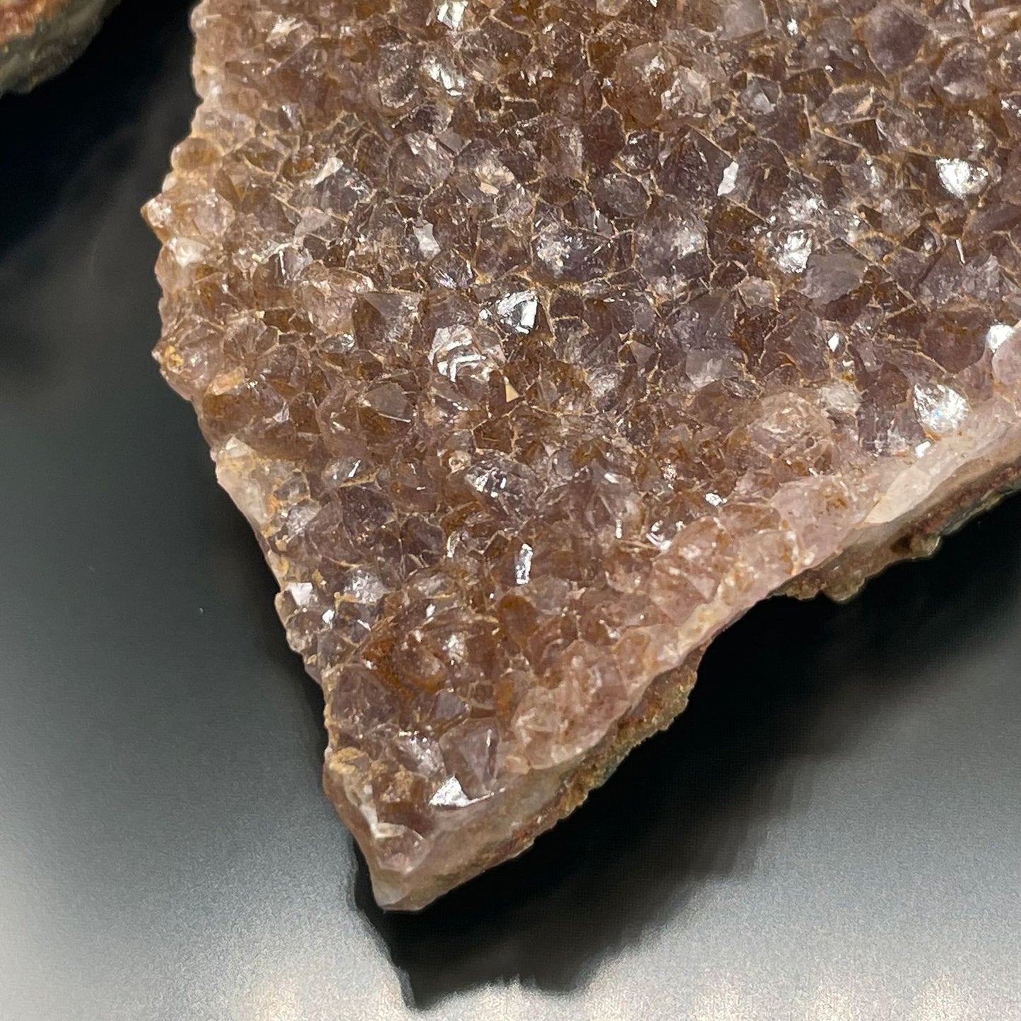 Ein Stück roher Amethyst mit vielen kleinen, glänzenden Kristallen.