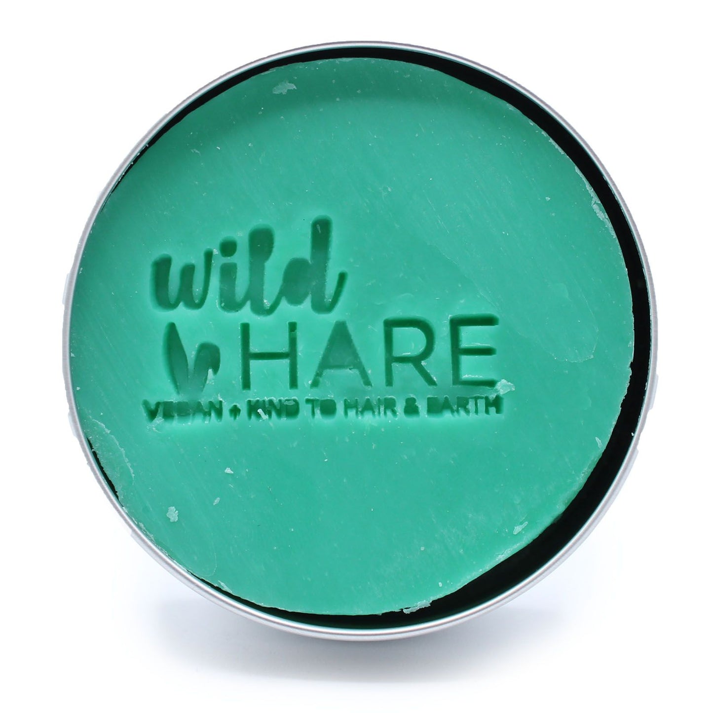 A green solid shampoo bar in a tin with the Wild Hare logo.
