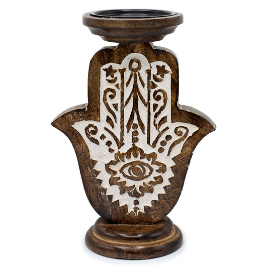 Mango wood candle stand carved in the shape of a Hamsa hand with white detailing.