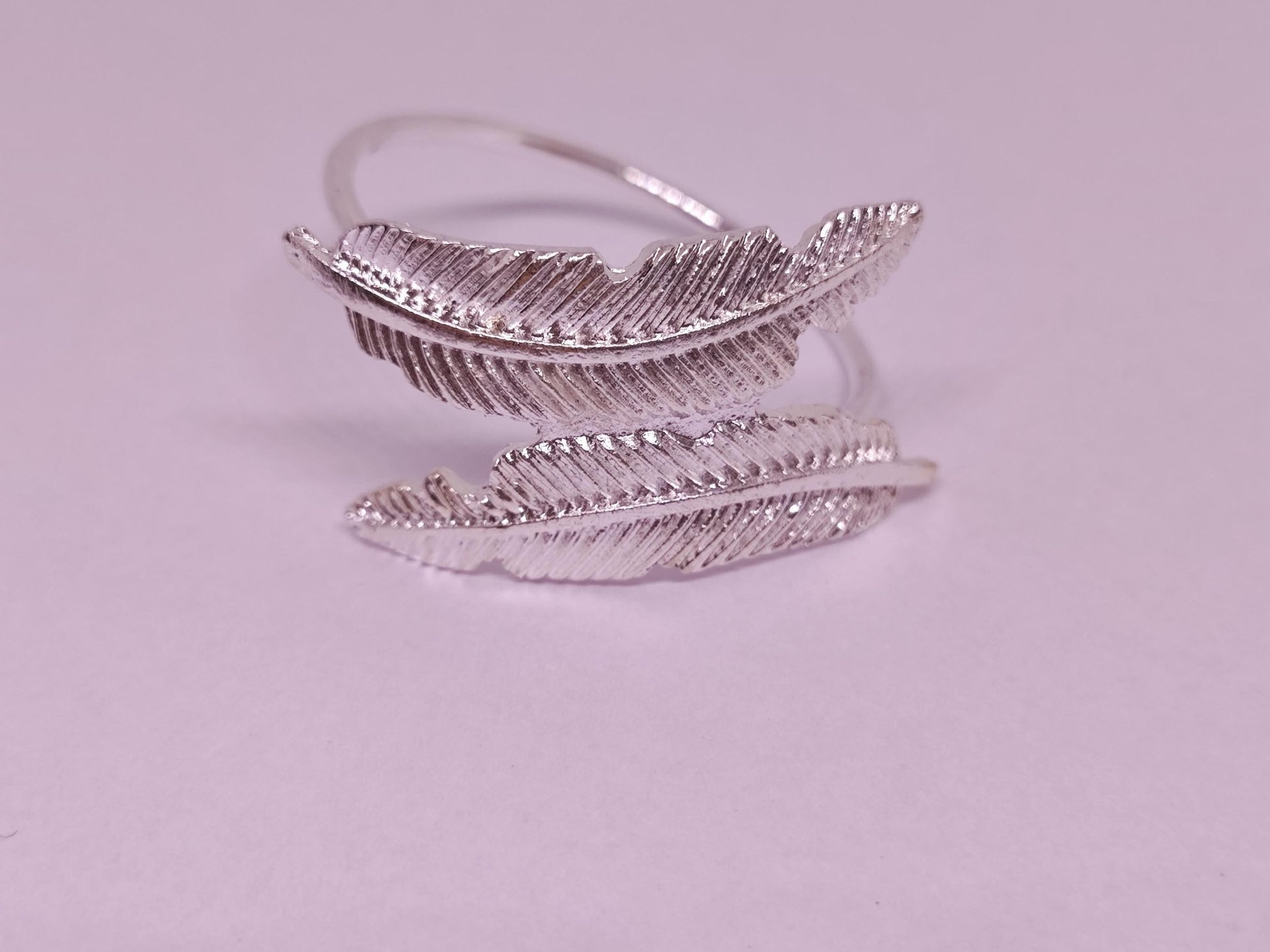Silberner Ring mit zwei Feder-Motiven.