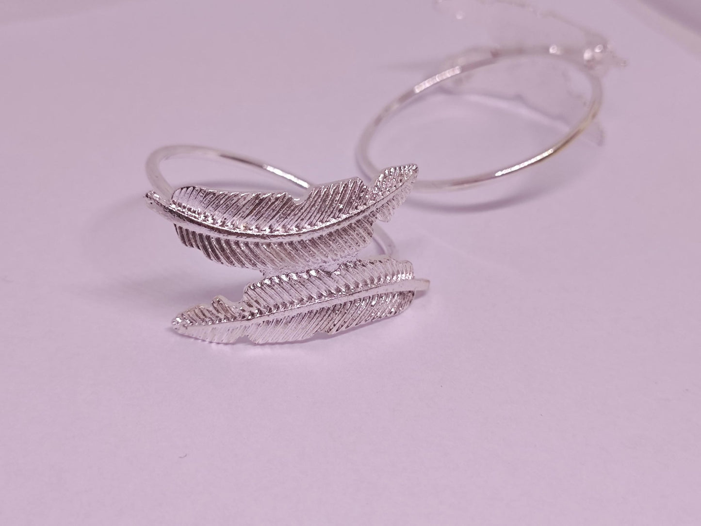 Silberner Ring mit zwei Feder-Ornamenten.