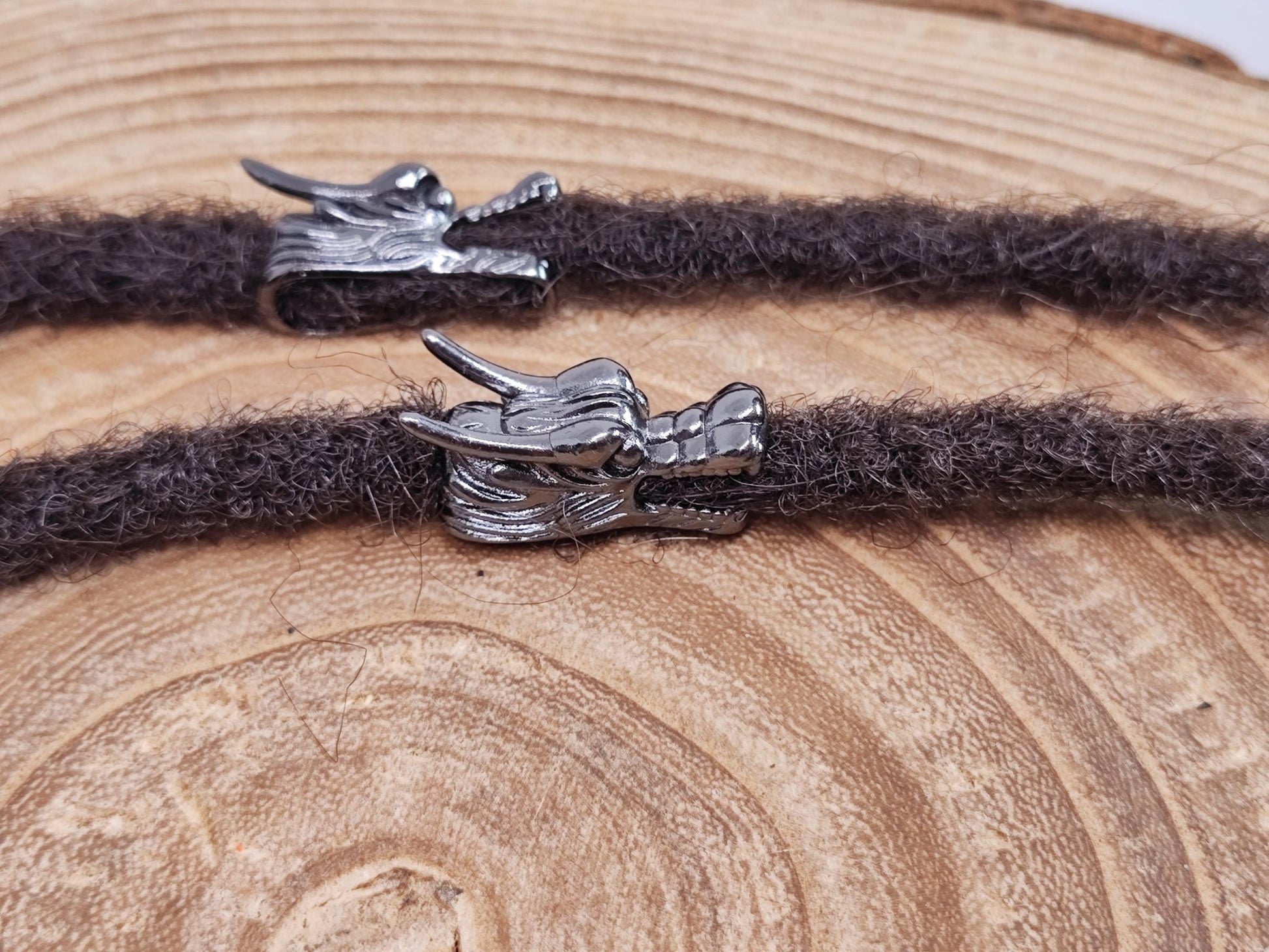 Dreadperle mit Drachenkopf-Motiv aus Metall.