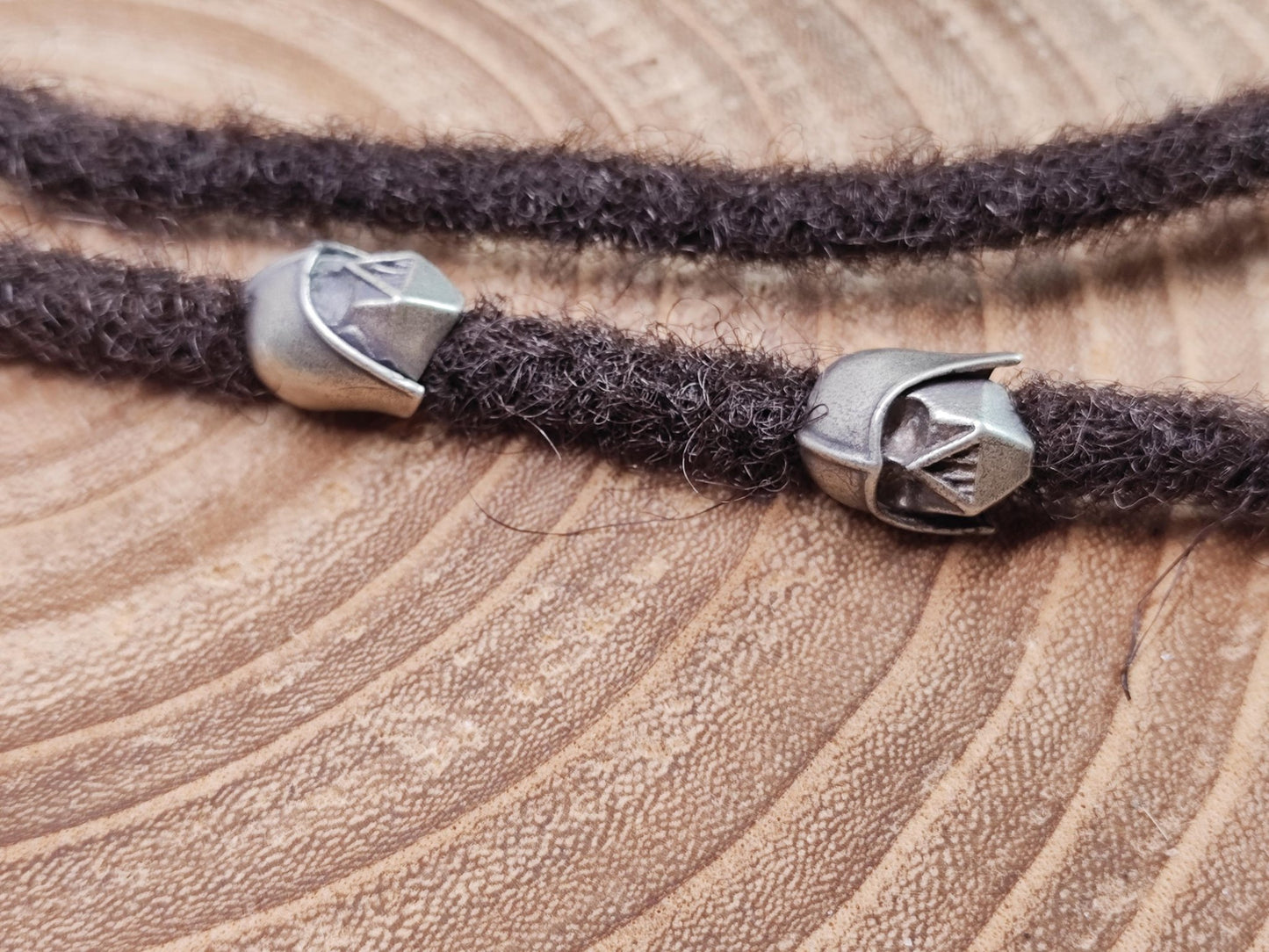 Dreadperle mit Star Wars Motiv aus Messing auf dunklen Dreadlocks.