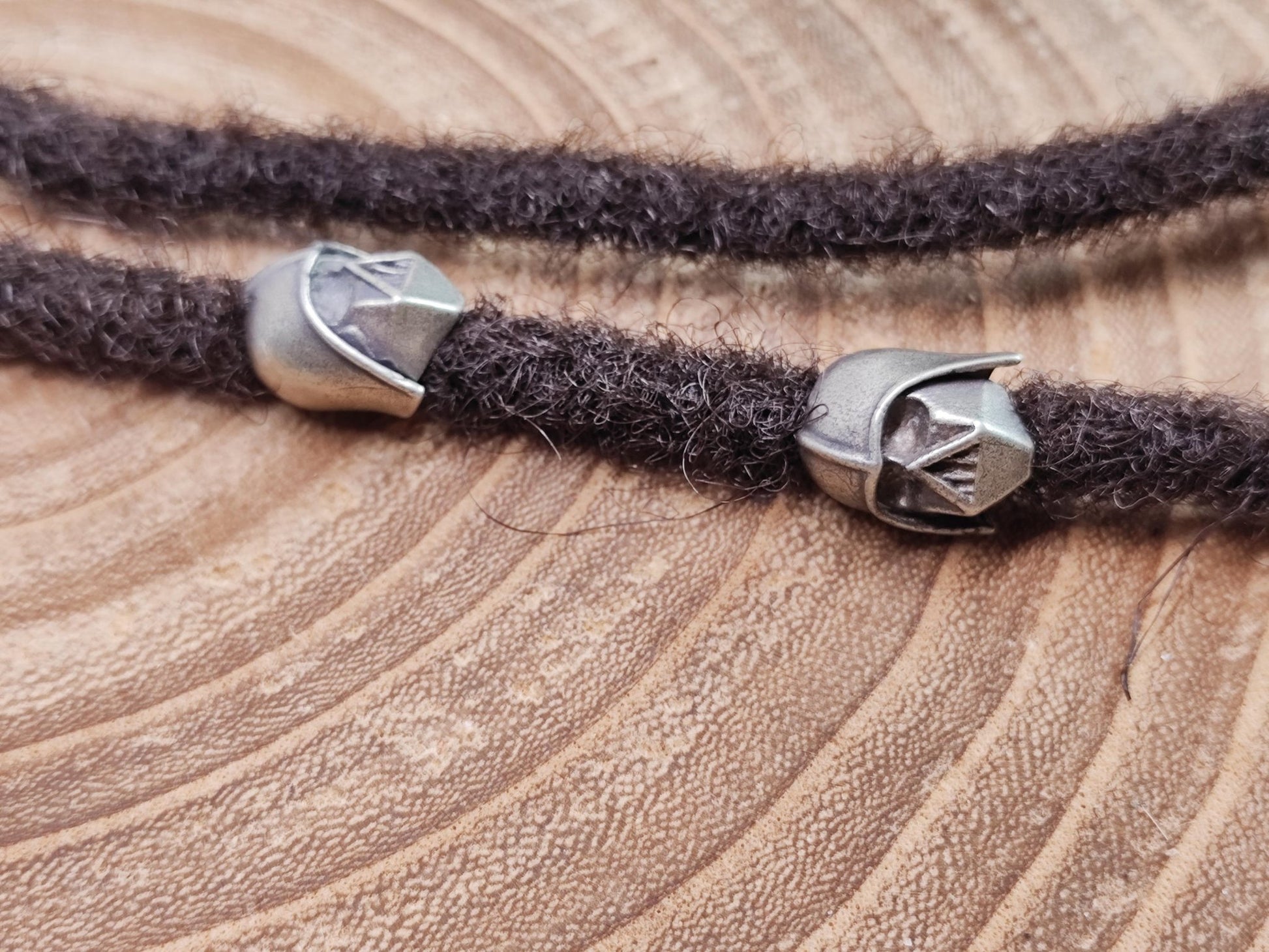Dreadperle mit Star Wars Motiv aus Messing auf dunklen Dreadlocks.