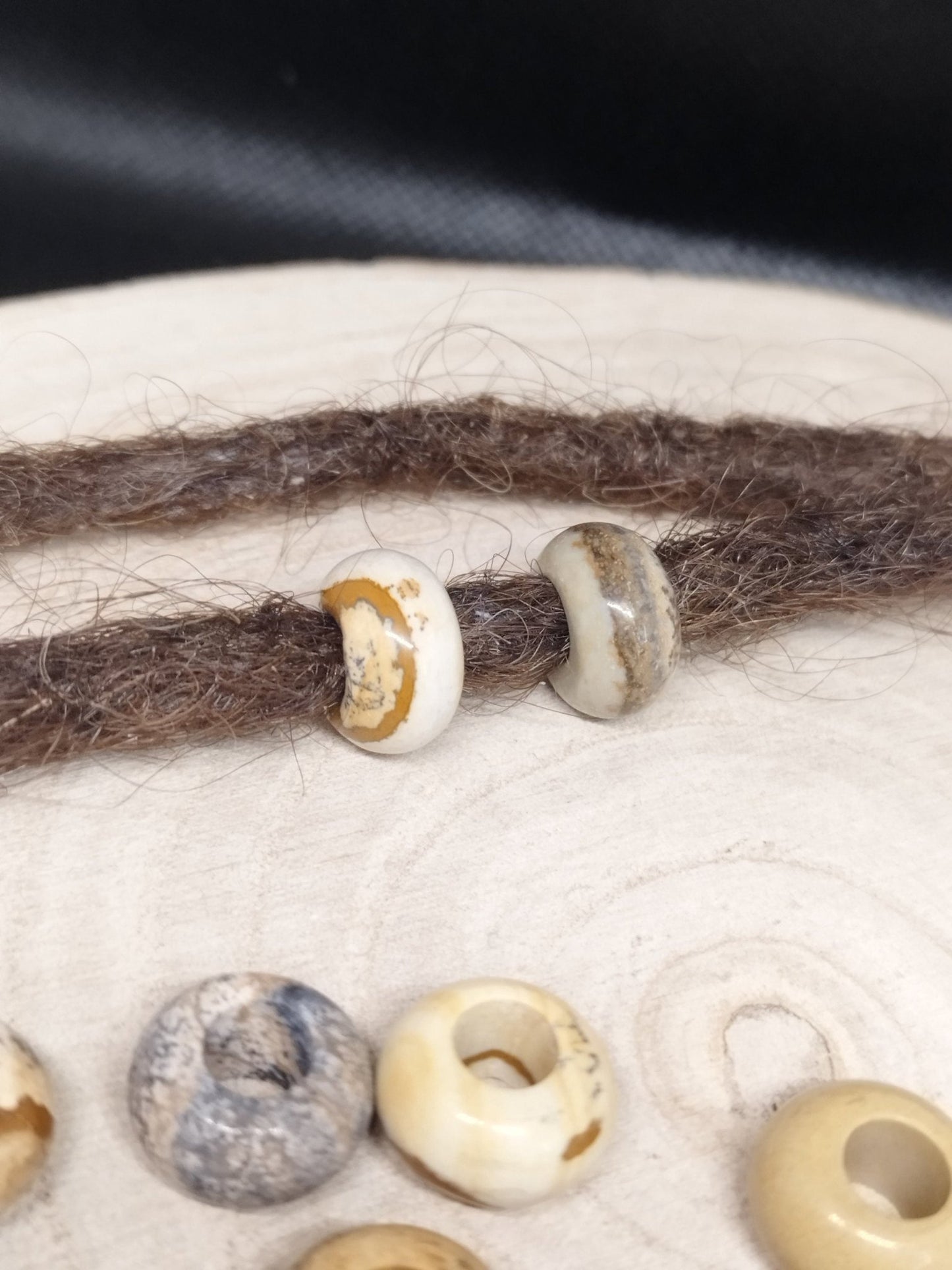 Großlochperle aus Bilderjaspis mit braunen Dreadlocks.