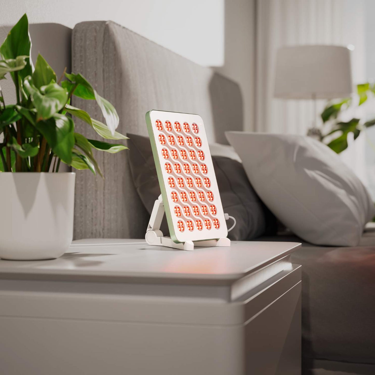 Nanoleaf Rotlichttherapie-Panel mit roten LEDs auf einem Nachttisch.