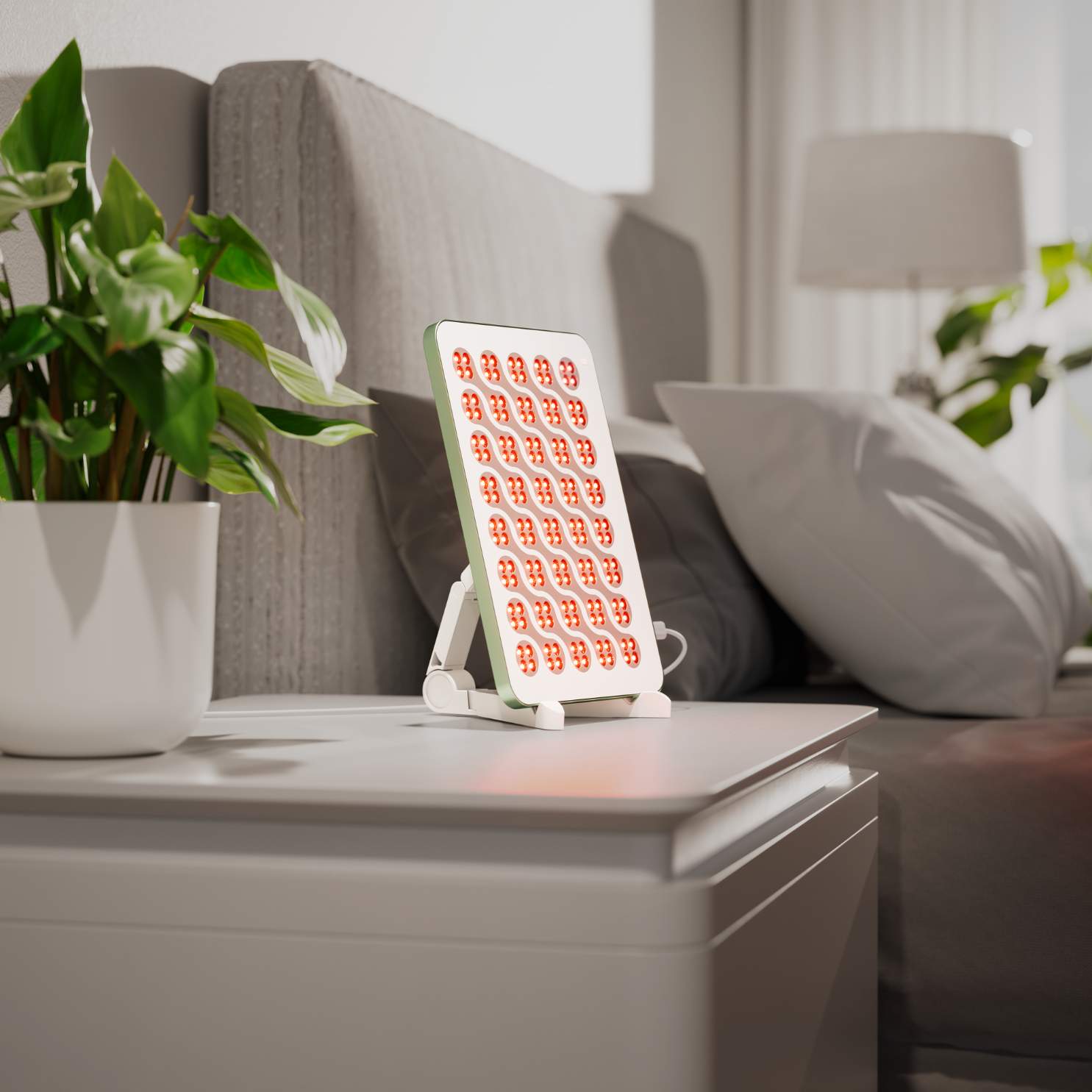Nanoleaf Rotlichttherapie-Panel mit roten LEDs auf einem Nachttisch.