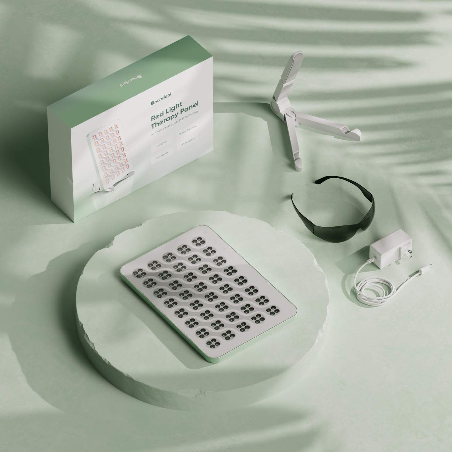Nanoleaf Rotlichttherapie-Panel mit Zubehör auf einem mintgrünen Hintergrund.